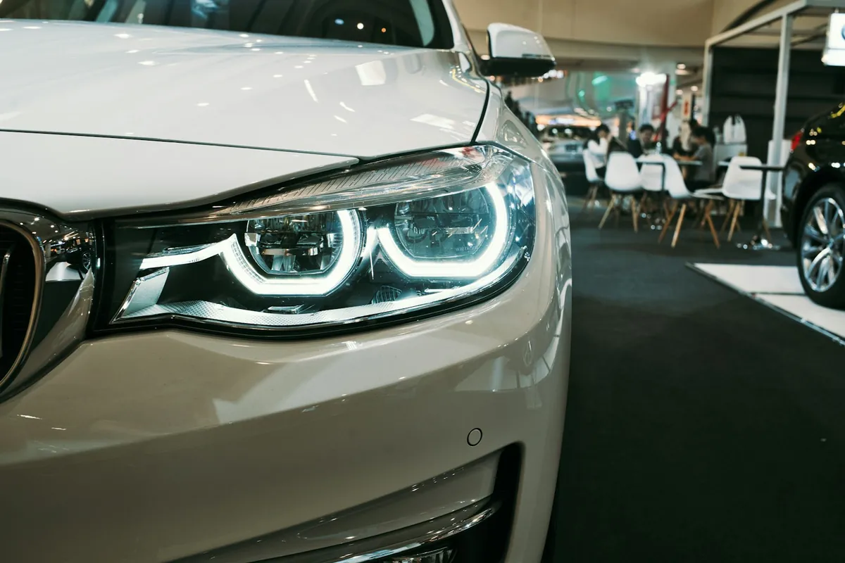 The headlight of a car on a showroom floor