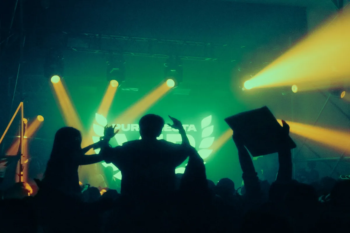 A crowd at a concert under bright stage lights